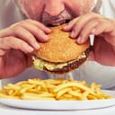 A man eating hamburger and fries