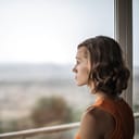 A sad woman looking out the window