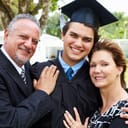 A male graduate in uniform being embraced by his parents