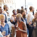 diverse group of people enjoying a buffet at a university alumni event