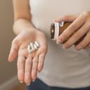 close-up of young woman's hand holding pills