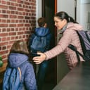 a mother and two kids leaving an apartment in a rush with backpacks on their backs