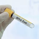 A person holding a vial of blood prepared for DNA testing
