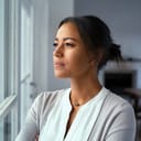 Woman pensively looking through a window