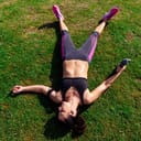 woman laying on grass in sport attire