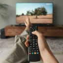 woman holding remote control while watching a documentary on TV