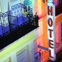 a neon hotel sign next at night in Buenos Aires