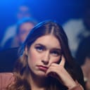 Woman watching a movie in a cinema with a bored look on her face