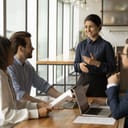 young businesswoman smiling as she leads a corporate meeting in the office