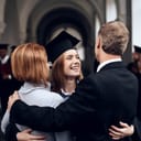 joyful parents celebrating their child's graduation from university, hugging their daughter after the ceremony