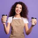 Female barista holding a cup of coffee in each hand with a big smile on her face