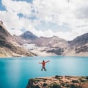 A woman jumping in front of a McArthur Lake, Canada