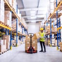 A storage worker placing boxes on the pallet lift