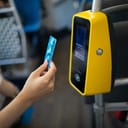 A woman using a ticket machine in a bus