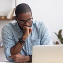 portrait of young serious businessman, looking at his laptop in the office