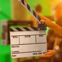 A person holding an open clapboard at a movie set