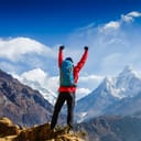 Hiker cheering elated and blissful with arms raised in the sky after hiking. Everest base camp trek