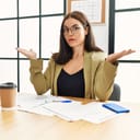 A serious businesswoman spreading her arms showing her not being aware of the issue