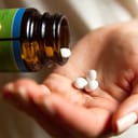 Woman taking out pills out of the bottle into her palm