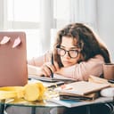 Bored young woman studying at home