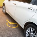 White car parking on handicapped parking sign area at asphalt parking lot, special car parking area for handicapped people only