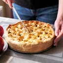 A person cutting an apple pie