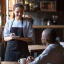 Waitress female welcoming diverse cafeteria pub guests african guy mixed race girl making order waiting staff writing wishes on notepad. Good service dining time, friends meets in public place concept
