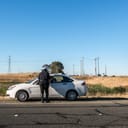A police officer standing near a vehicle they stopped because of a violation