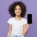 A young girl smiling showing her smartphone against a purple background
