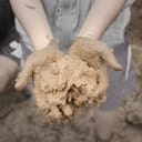 Person holding raw clay in their hands