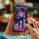 Man Scrolling Feed of Social Media Application and on Display on Smartphone