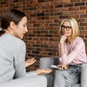 young woman discussing her concerns with a psychologist who is taking notes