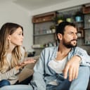 A young woman trying to apologize to a man