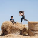 Children playing on hay bales.