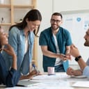 Smiling diverse colleagues gather in boardroom brainstorm discuss financial statistics together, happy multiracial coworkers have fun cooperating working together at office meeting, teamwork concept