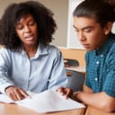 High school tutor providing one-on-one instruction to a male student at a desk.