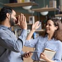 Two professionals celebrating success with a high five in the office