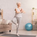 Elderly woman practicing yoga indoors