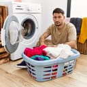 Sad man with a basketful of laundry ready to fill up the washing machine