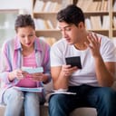 young couple discussing finances while seated on a couch in their living room