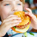 Small boy eating a hamburger