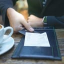 A person giving their credit card in order to pay a bill in a restaurant