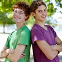 Two young boys leaning against each other's backs