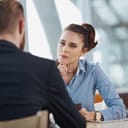 A female manager attentively listening to a male employee during a meeting in the office.