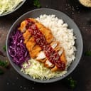 Crispy Katsu chicken with sauce, rice and cabbage.
