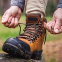 Woman tying shoelace on her hiking boot. 