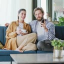 A couple sitting on a couch watching television