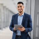 Smiling young businessman holding a tablet