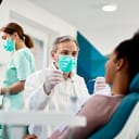 male dentist smiling and talking with a female patient during a dental check-up