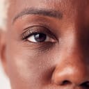 A closeup of a person's face with their eye in focus